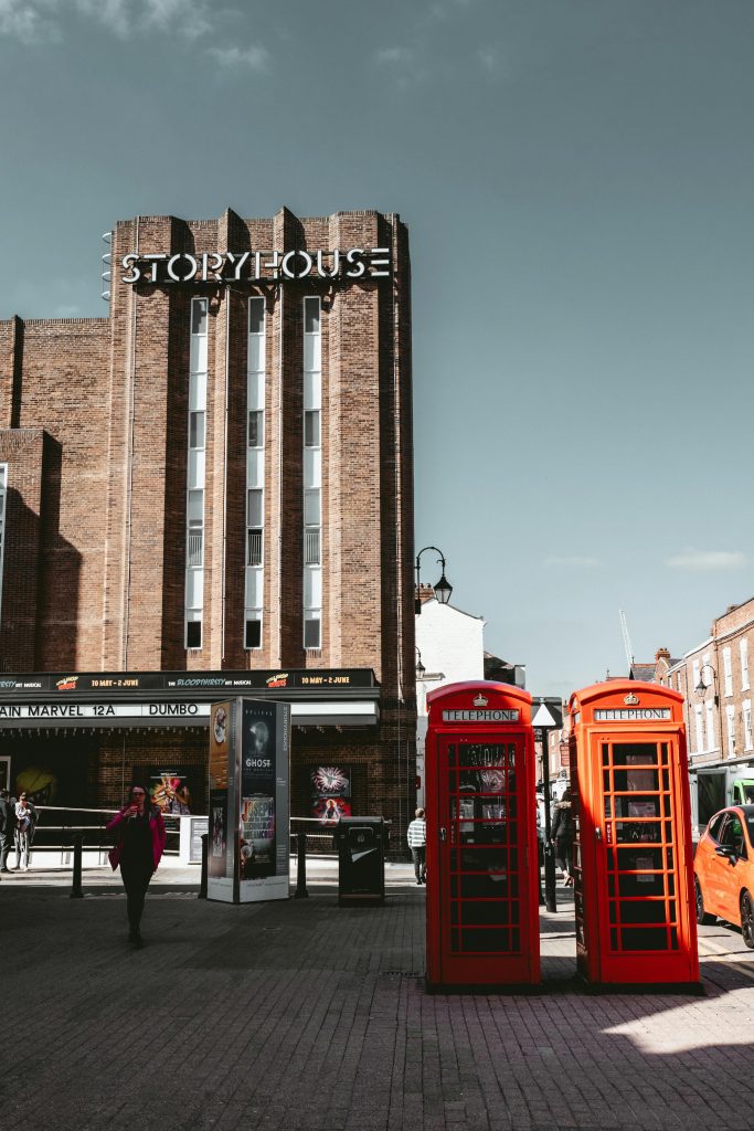 Historic red telephone booths outside Storyhouse Theater in Chester, England.
