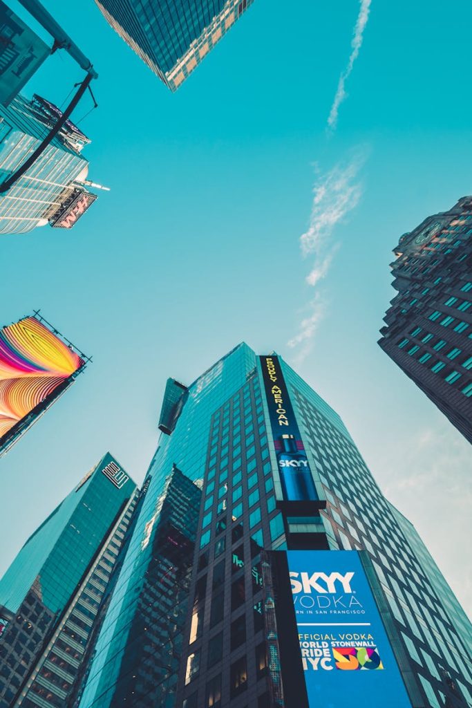 A low angle view of colorful skyscrapers in New York City with vivid signage.