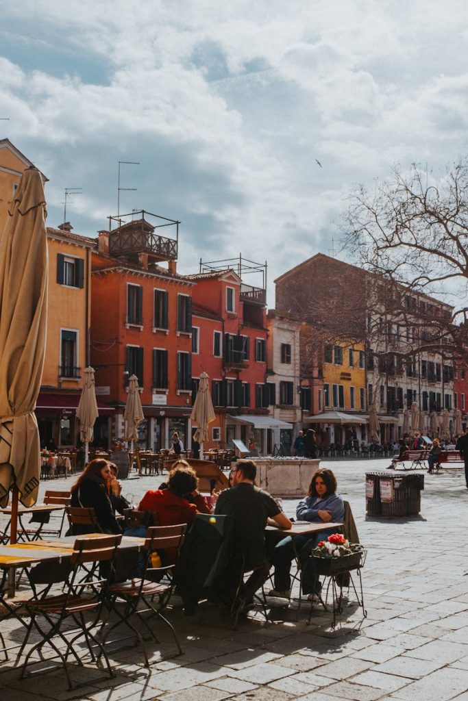 Charming Venetian plaza bustling with life, colorful buildings and cafes, creating a vibrant European atmosphere.